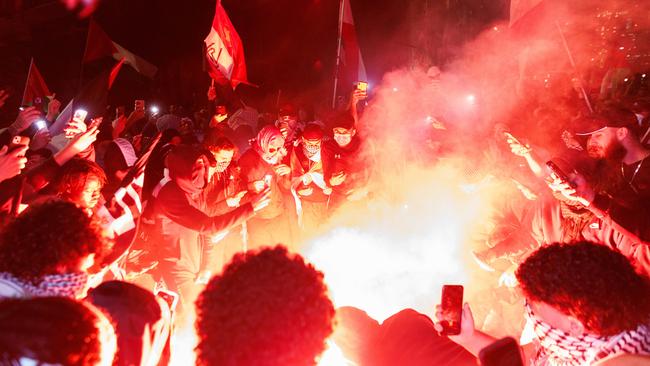 Pro-Palestine supporters light flares at the Sydney Opera House on Monday night. Picture: David Swift