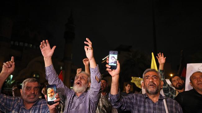 Men show photos of Hassan Nasrallah, Secretary-general of Hezbollah, as people demonstrate against Israel and the attack on Lebanon at Palestine square in Tehran. Picture: AFP