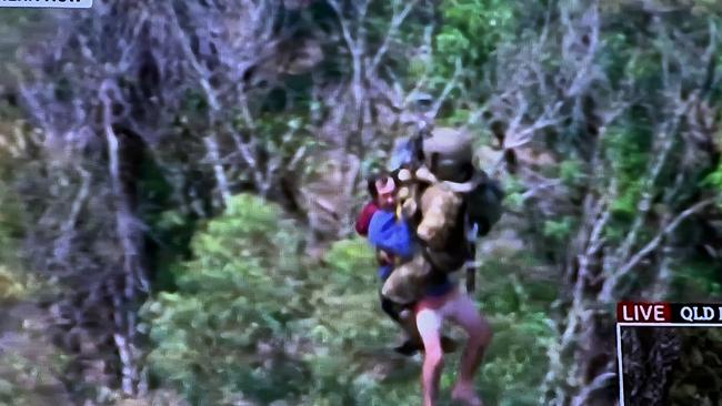 SKY TV frame grabs of a live rescue from the top of a in Lismore roof by the defence force - a man is pictured being airlifted to a helicopter.