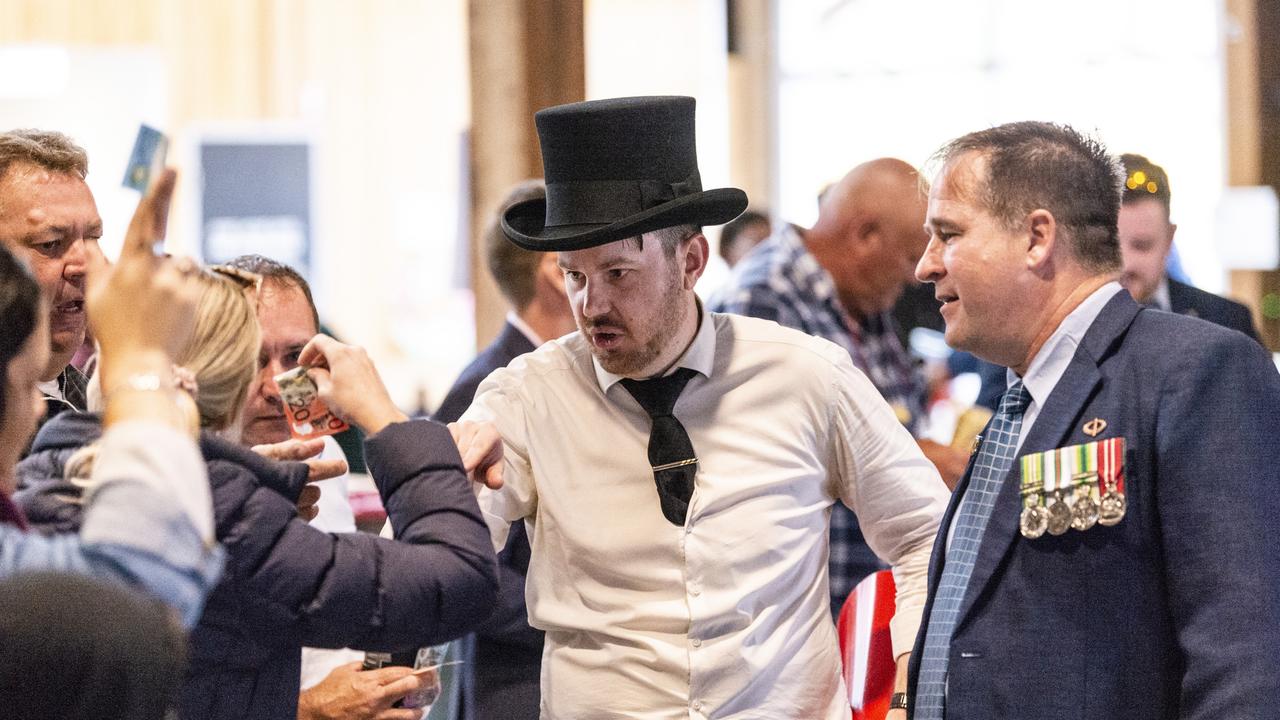 Ringkeeper Sheldon Rogers and helper David Kelly during two-up in the Goods Shed as part of Toowoomba Anzac Day commemorations, Monday, April 25, 2022. Picture: Kevin Farmer