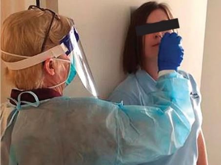 A hotel quarantine worker demonstrates the doorway swabbing technique now blamed for allowing COVID-19 to escape room 317 at the Holiday Inn at Melbourne Airport. Picture: Supplied