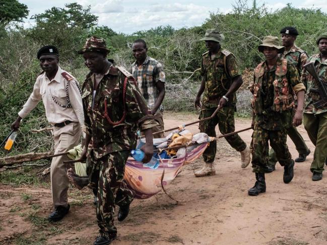 TOPSHOT - Security personnel carry a rescued young person from the forest in Shakahola, outside the coastal town of Malindi, on April 23, 2023. - Twenty-one bodies have been exhumed in Kenya while investigating a cult whose followers are believed to have starved themselves to death, police sources said on April 22, 2023, warning the toll could rise. (Photo by Yasuyoshi CHIBA / AFP)