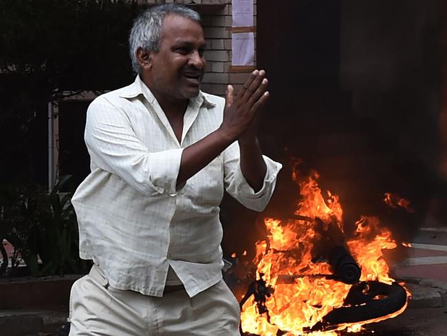 A follower of Indian religious leader Gurmeet Ram Rahim Singh pleads for his safety after being hit with a stick during clashes between the controversial guru's followers and security forces in Panchkula on August 25, 2017. At least four people were killed on August 25 when clashes broke out in northern India after a court convicted a controversial religious leader of raping two of his followers, sparking fury among tens of thousands of supporters who had gathered to await the verdict.  / AFP PHOTO / MONEY SHARMA