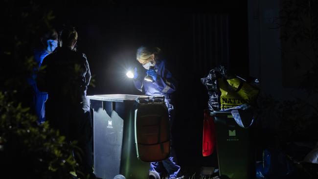 Missing Persons Squad detectives search for evidence in garbage bins. Picture: Jason Edwards