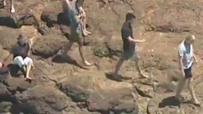 People on the headland looking down at the water where Dylan went missing.