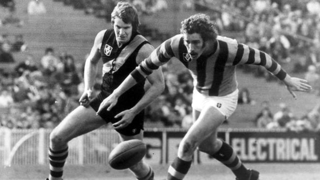 Hawthorn's Kelvin Moore leads Royce Hart to the ball at the MCG.