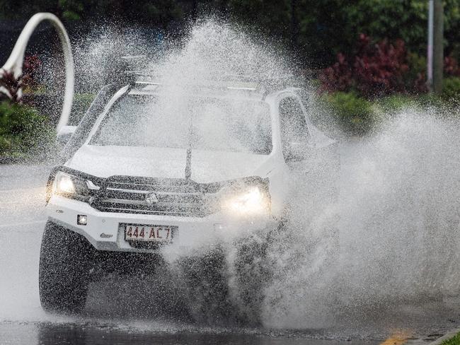 A car drives through flash flooding on Milton road on Tuesday. Picture Lachie Millard