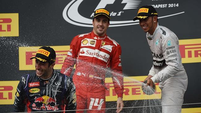 Australian driver Daniel Ricciardo, left, winner of the Hungarian Grand Prix, celebrates with Spanish driver Fernando Alonso, centre and second in the race, and British driver Lewis Hamilton, third.