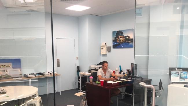 Builder Adrian Hill was photographed working in an office in Broadbeach displaying his construction company's signage despite him and the company being unlicensed. Photo: Supplied 