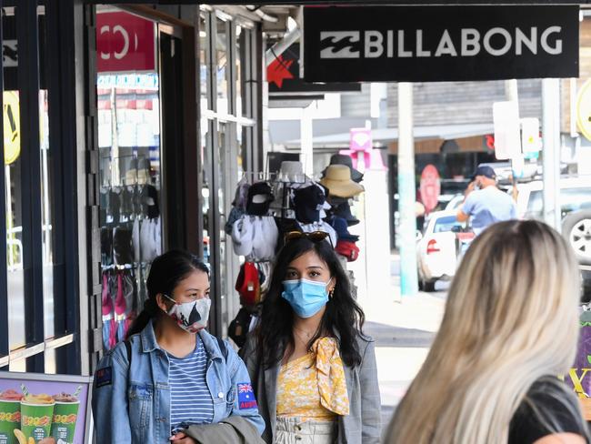 BYRON BAY, AUSTRALIA - MARCH 31: People wearing face masks walk along a street on March 31, 2021 in Byron Bay, Australia. The NSW Government has reintroduced restrictions for residents of Byron, Ballina, Tweed and Lismore shires after a new COVID-19 case was recorded in the area, linked to the current Brisbane coronavirus outbreak. Household gatherings will be limited to 30 people, venue caps will return to the four-square-meter rule and masks will be mandated in retail and public transport settings. The restrictions will remain in place until 11:59 pm on Monday 5 April. (Photo by James D. Morgan/Getty Images)