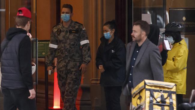 A quarantine staff member opens the door at the Intercontinental Hotel in Melbourne on Tuesday. Picture: Daniel Pockett