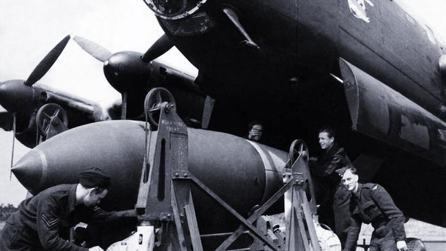 Members of Bomber Command load a bomb onto a Lancaster II bomber.