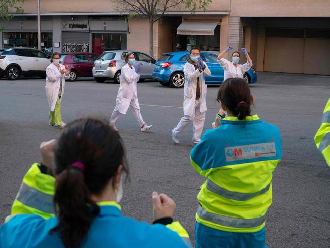 Members of the Comunidad de Madrid's Biological Risk Medical Emergency Service and healthcare workers applaud each other in Madrid. Picture: Comunidad de Madrid/AFP