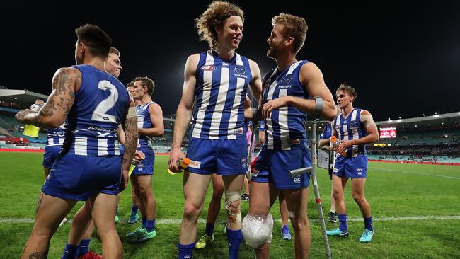 Ben Brown supports North Melbourne teammate Ed Vickers-Willis after he suffered a knee injury. Picture: Mark Metcalfe/Getty Images.