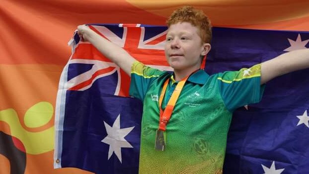 Robbie Yates with the Australian Flag at the World Transplant Games in Perth. Picture: Supplied