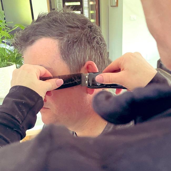 Daniel Andrews gets a home haircut from wife Catherine. Picture: Twitter/@CathLAndrews