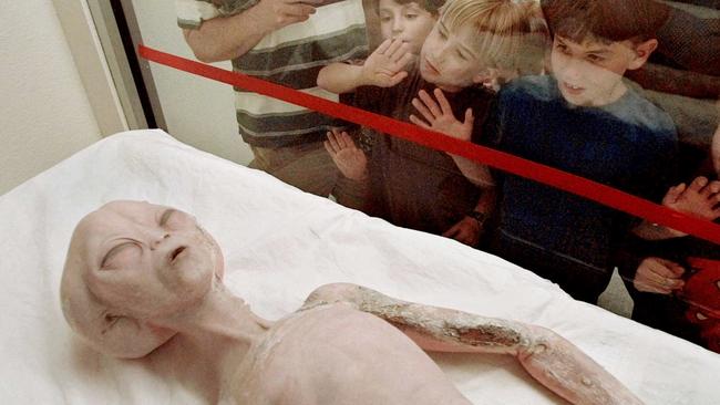 Children eye a model of an alien at the International UFO Museum and Research Center in Roswell, New Mexico.