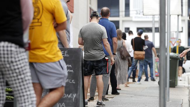 Voters pictured at 52 McLachlan St, Fortitude Valley queueing a safe distance apart waiting to pre poll vote ahead of tomorrow council election, Brisbane 27th of March 2020.  Coronavirus (Covid-19) has prompted a number of people to vote early.  (AAP Image/Josh Woning)