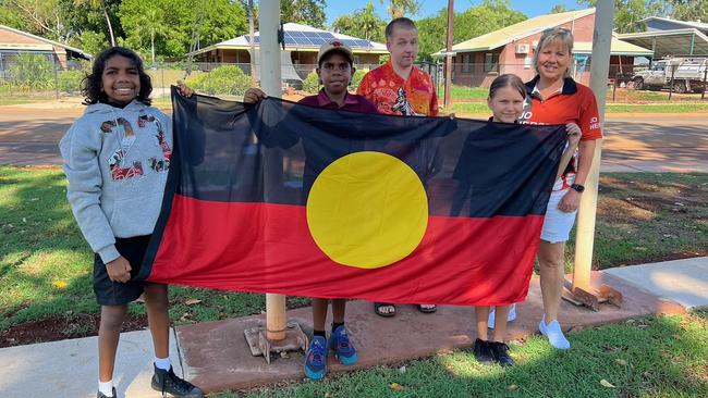 Jo Hersey presenting an Aboriginal flag to Macfarlane Primary School, Katherine. Picture: Supplied