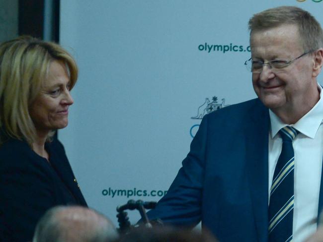 Australian Olympic Committee (AOC) chief John Coates (R) shakes hands with challenger Danni Roche (L) after beating her in votes to remain the president of the AOC at their annual general meeting in Sydney on May 6, 2017.  Coates, who has been the AOC president for 27 years, won a secret ballot 58-35 after a bitter campaign with challenger Roche for the presidency at the AOC AGM in Sydney / AFP PHOTO / PETER PARKS