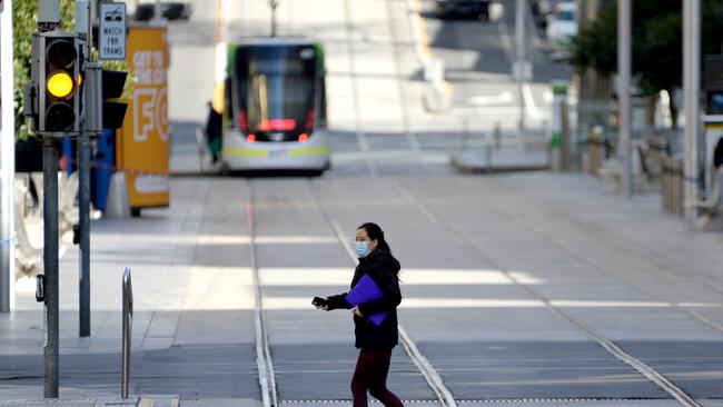 A person walks past a deserted Bourke Street Mall in Melbourne's CBD during the state's latest lockdown. Picture: NCA NewsWire / Andrew Henshaw