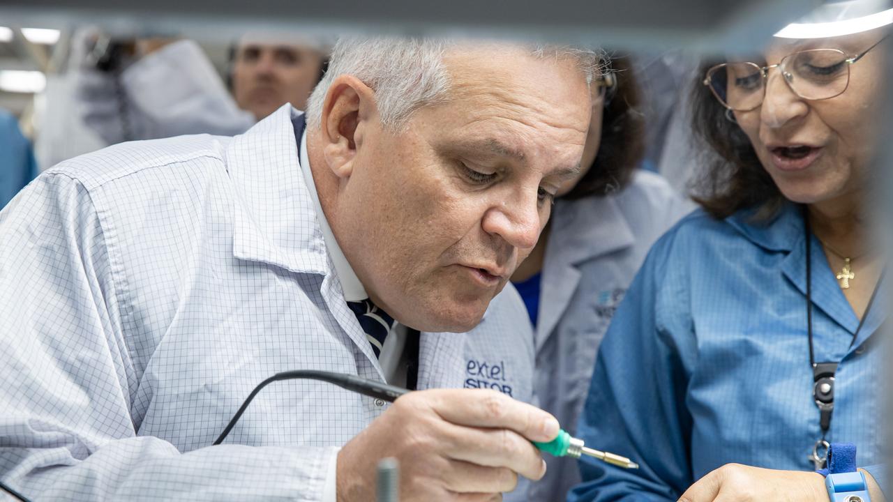 Joanna Konstandinou, Hampton Park, watches on as Mr Morrison tries his hand at soldering microchips. Picture: Jason Edwards