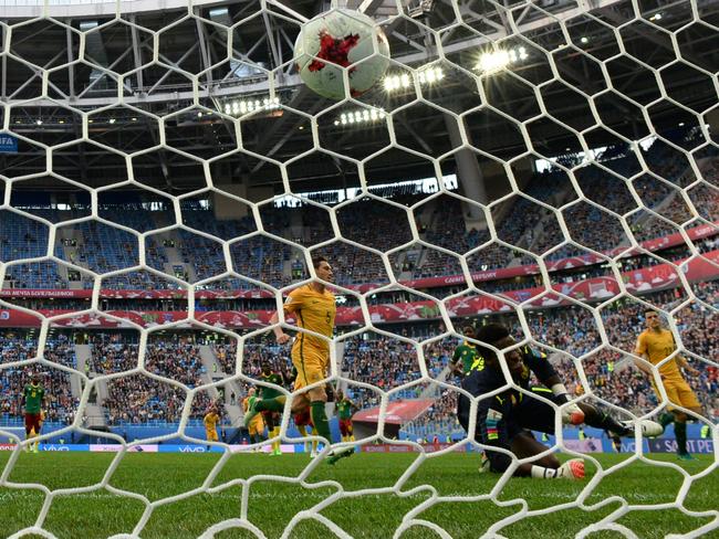 Cameroon's goalkeeper Joseph Ondoa can’t stop Mark Milligan’s penalty shot.