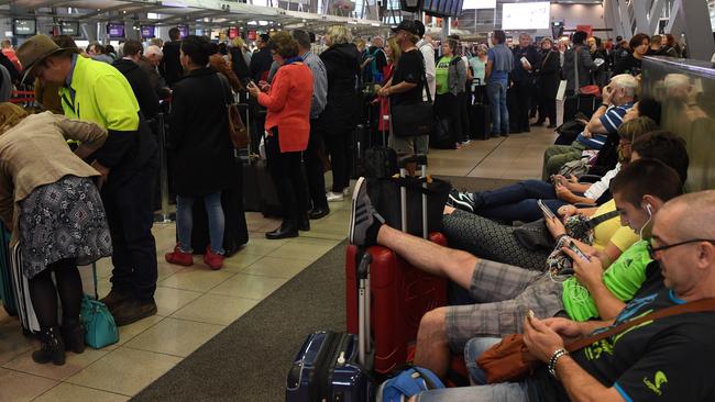 Passengers put their feet up for a rest during check-in for Virgin flights in Sydney. Picture: AAP