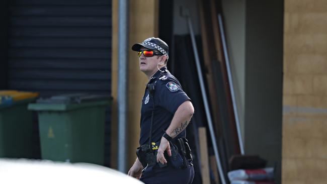 A police officer patrols North Lakes State College this morning. Picture: Annette Dew