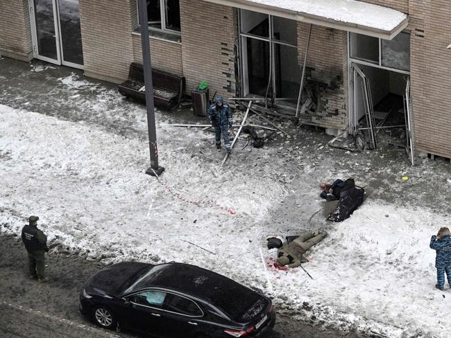 EDITORS NOTE: Graphic content / TOPSHOT - Bodies are seen at the blast scene, which killed the commander of Russian armed forces' chemical, biological and radiation defence troops, Igor Kirillov, and his assistant, according to the Russian Investigative Committee, outside a residential building on Ryazansky Avenue in Moscow on December 17, 2024. (Photo by Alexander NEMENOV / AFP)