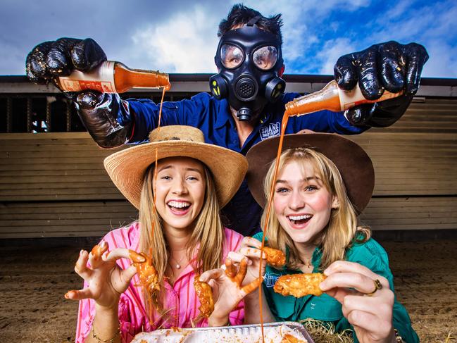 Amelia Feltham and Eva Henderson have a little Ghost of Chainsaw hot sauce added by Shank Brothers’ Ralph Barnett. Picture: Nigel Hallett