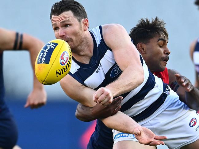 MELBOURNE, AUSTRALIA - JUNE 28: Patrick Dangerfield of the Cats handballs whilst being tackled by Kysaiah Pickett of the Demons during the round 4 AFL match between the Melbourne Demons and the Geelong Cats at Melbourne Cricket Ground on June 28, 2020 in Melbourne, Australia. (Photo by Quinn Rooney/Getty Images)