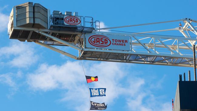 The CBUS and CFMEU flags flying on a crane at a worksite in Mascot. Picture: Justin Lloyd.