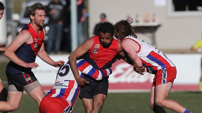 Swifts Creek’s Nathan Hayes is gang tackled by Lindenow South’s Christopher Richardson and William O'Keefe. Picture: Yuri Kouzmin