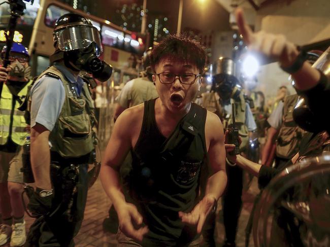 A man reacts as policemen with riot gears ask him to move during a protest in Hong Kong. Picture: AP