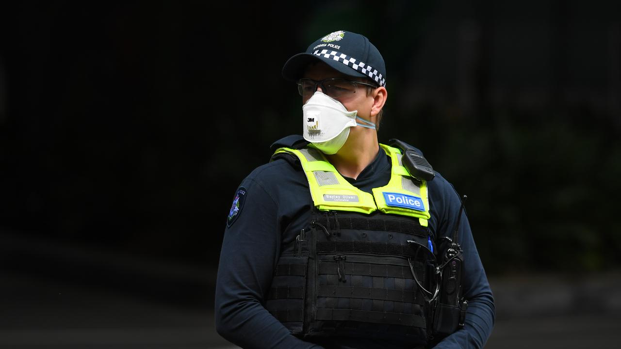 A Victorian Police officer wearing a face mask is seen outside of Crown Metropol Hotel two days into the hotel quarantine scheme.