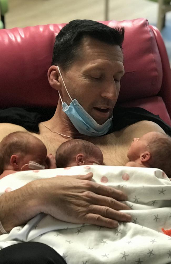 The triplets with their father after birth.