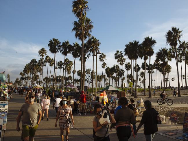 People walk along the boardwalk at Venice Beach, California. Picture: Angus Mordant