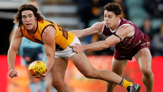 Jai Newcombe fires off a handball in front of Brisbane Brownlow Medallist Lachie Neale. Picture: Dylan Burns/AFL Photos