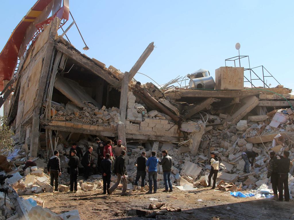 People gather around the rubble of a hospital supported by Doctors Without Borders (MSF) near Maaret al-Numan, in Syria’s northern province of Idlib, on February 15, 2016, after the building was hit by suspected Russian air strikes. MSF confirmed in a statement that a hospital supported by the aid group in Idlib province was “destroyed in air strikes”. Picture: AFP / AL-MAARRA TODAY / GHAITH OMRAN