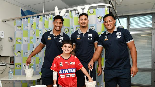 Nate Melori, 10, receives Easter treats from Cowboys players Murray Taulagi, Robert Derby and Viliami Vailea at the Children's Ward, Townsville University Hospital. Picture: Shae Beplate.