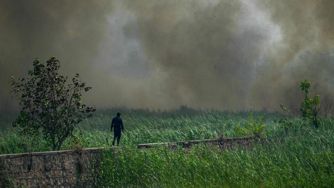 A firefighter arrives to douse flames at the grasslands of Yamuna flood plains in New Delhi. Picture: Arun Sankar/AFP