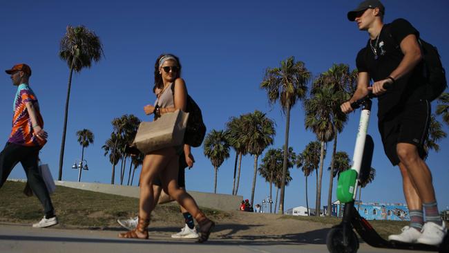 A man rides a Lime shared dockless electric scooter along Venice Beach. Pic: Getty Images