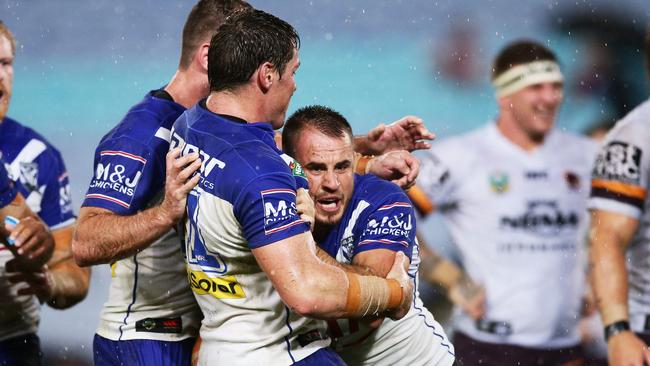 Josh Reynolds celebrates with teammates after scoring a try for the Bulldogs against the Broncos.