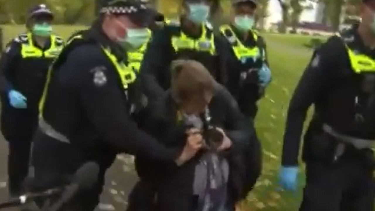 Police surrounded the woman and led her away while she attempted to take photos.