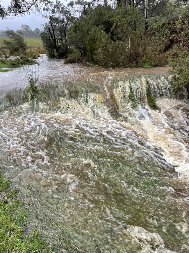 Water flows over a farm driveway in Lancefield on October 13. Picture: Zoe Phillips