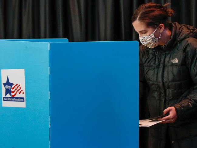 A woman casts her ballot at the United Center on Election Day in Chicago, Illinois, on November 3, 2020. - Americans were voting on Tuesday under the shadow of a surging coronavirus pandemic to decide whether to reelect Republican Donald Trump, one of the most polarizing presidents in US history, or send Democrat Joe Biden to the White House. (Photo by KAMIL KRZACZYNSKI / AFP)