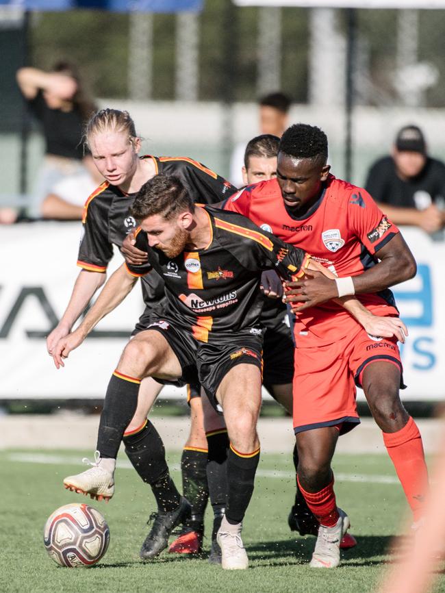 Hamish Gow, Dylan Smith and Pacifique Niyongabire trying to get the ball during Adelaide United youth’s clash against MetroStars match on Sunday. Picture: AAP/Morgan Sette