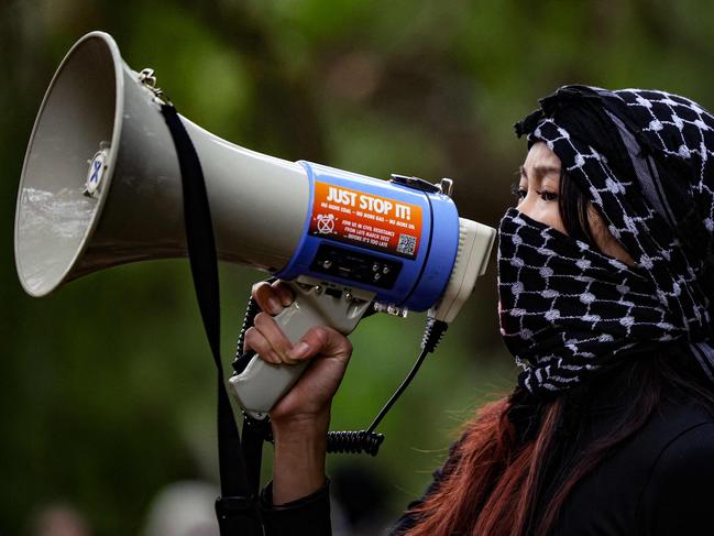 A student shouts slogans into a megaphone as pro-Palestinian students hold a sit-in in Melbourne on May 15, 2024 at Melbourne University's Arts West building, which the students have temporarily renamed as "Mahmoud's Hall" after Mahmoud Al Haq, a prospective University of Melbourne student, who died in Gaza. (Photo by Martin KEEP / AFP)