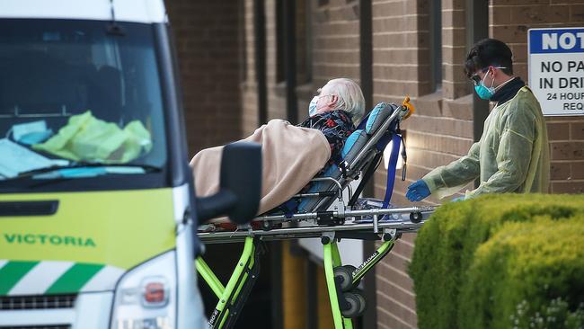 An elderly resident is transported out of[ Menarock LIFE Aged Care in Essendon. Picture: Ian Currie